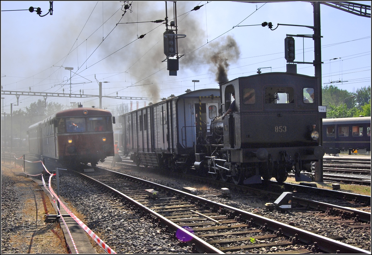 Hier rangiert E 3/3 853 der Jura-Simplon Bahn. Durch die Rauchschwaden kämpft sich der Schienenbus 796 739 des DDM. Sommer 2009.