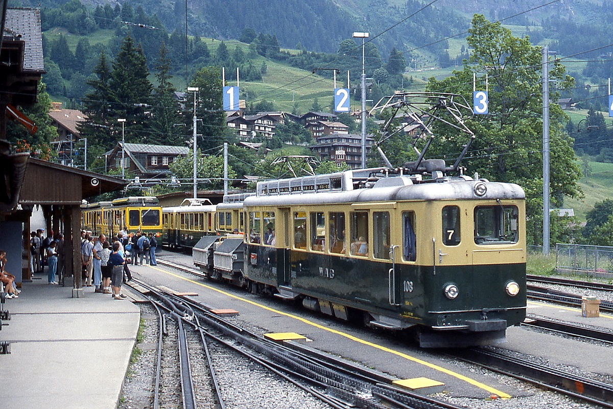 Hochbetrieb im Bahnhof Wengen: BDhe 4/4 108 (das  A  entfiel nach Abschaffung der 1. Klasse im Jahre 1982) trifft auf einen weiteren - teilweise verdeckten - BDhe 4/4 sowie einen der 1988 in Dienst gestellten BDhe 4/8 131-134 (Juni 1990)