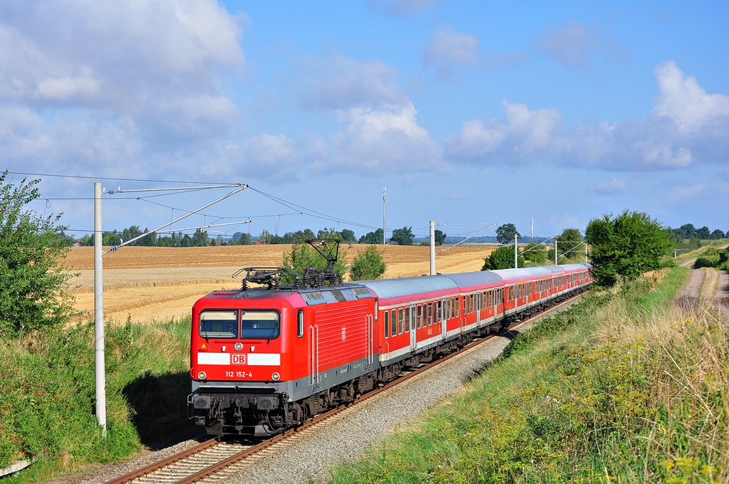 Ihren 11-Wagen starken Kreuzfahrerzug zieht die 112 152 am 31.07.2014 nach Berlin.Hier kurz vor Kavelstorf.Im Zug befanden sich Passagiere der in Warnemünde liegenden  Royal Princess .