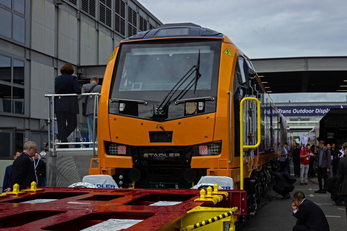 Im Au�enbereich der Messe Berlin sind die auf der InnoTrans pr�sentierten Fahrzeuge dicht an dicht aufgereiht und insbesondere im Bereich zwischen den Messehallen schwer zu fotografieren. So zum Beispiel 99002, die britische Variante der EuroDual von Stadler, die sich hinter einem Containerwagen versteckt.