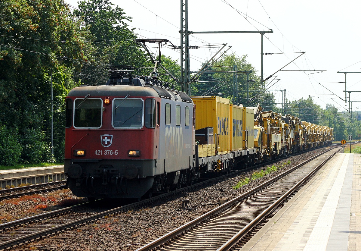 Im Einsatz für HSL fährt hier die SBB Cargo 4421 376-5 als Zuglok des DGV 92762(Wissen/Sieg/Löhne-Padborg/DK) mit einem Spitzke Bauzug, Bettungsreinigungsmaschine RMS 900/9980 9414 002-1 und Begleitwagen durch Schleswig. 04.07.2015