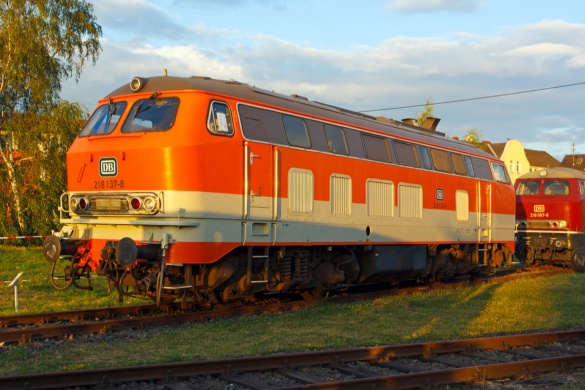 Im letzten Sonnenlicht....
Die ehemalige City-Bahn Lok 218 137-8 in orange/kieselgrau am 14.06.2014 im DB Museum Koblenz.

Die V 164 wurde 1971 bei Henschel in Kassel unter der Fabriknummer 31539 gebaut und als 218 137-8 an die DB (in altrot) geliefert. Fr das Projekt CityBahn auf der Strecke Kln – Gummersbach (Aggertalbahn) wurden 1984 zehn Lokomotiven des Betriebswerks Hagen passend zum Wagenzug in reinorange (RAL 2004) mit kieselgrauer Bauchbinde umlackiert, so auch dies Lok.

Technische Daten:
Achsformel:  B'B'
Spurweite:  1.435 mm
Lnge: 16.400 mm
Gewicht:  80 Tonnen
Radsatzfahrmasse:  20,0 Tonnen
Hchstgeschwindigkeit:  140 km/h
Motor: Wassergekhlter V 12 Zylinder Viertakt MTU - Dieselmotor vom Typ 12 V 956 TB 11 (abgasoptimiert ) mit Direkteinspritzung und Abgasturboaufladung mit Ladeluftkhlung
Motorleistung: 2.800 PS (2.060 kW) bei 1500 U/min
Getriebe: MTU-Getriebe K 252 SUBB (mit 2 hydraulische Drehmomentwandler)
Leistungsbertragung: hydraulisch
Tankinhalt:  3.150 l
