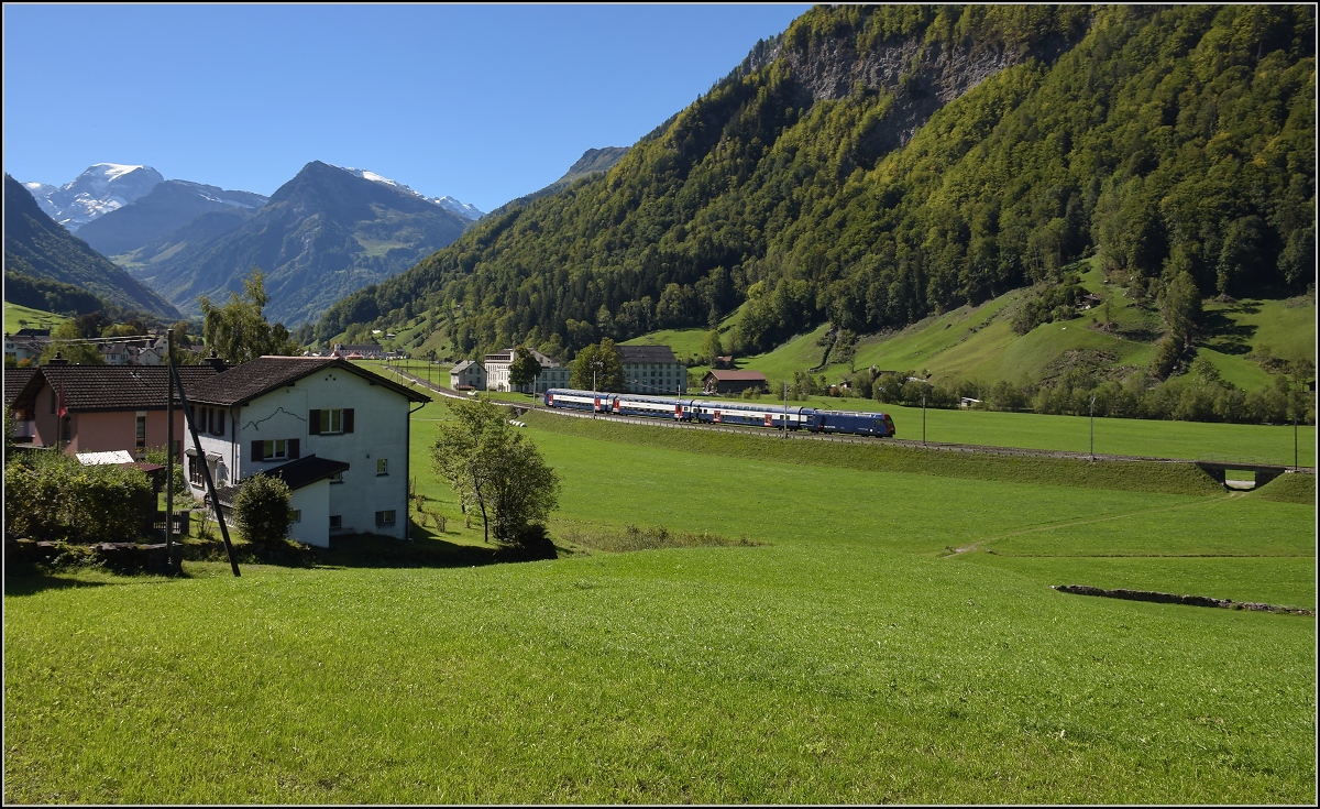 Im tiefeingeschnittenen Tal der Linth zeigt sich ein unbekannter Zug der S-Bahn Zürich mit Re 450 in ganz besonderem Licht. Im Hintergrund erhebt sich der Tödi, höchster Alpengipfel zwischen den Viertausendern von Berner Oberland und Berninamassiv. Diesbach, September 2019.