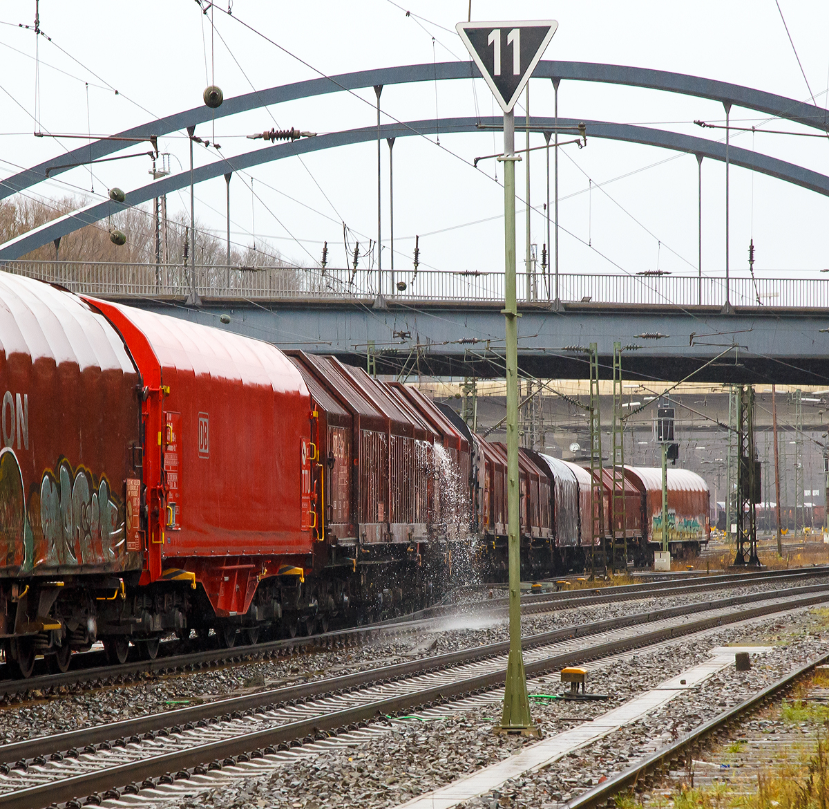 
Impression bei Regen....
Das Wasser läuft im Weichenbereich von einem Drehgestellflachwagen mit sechs Radsätzen, verschiebbaren Teleskophauben und Lademulden für Coiltransporte der Gattung Sahimms-u ab.
Kreuztal den 08.12.2018
