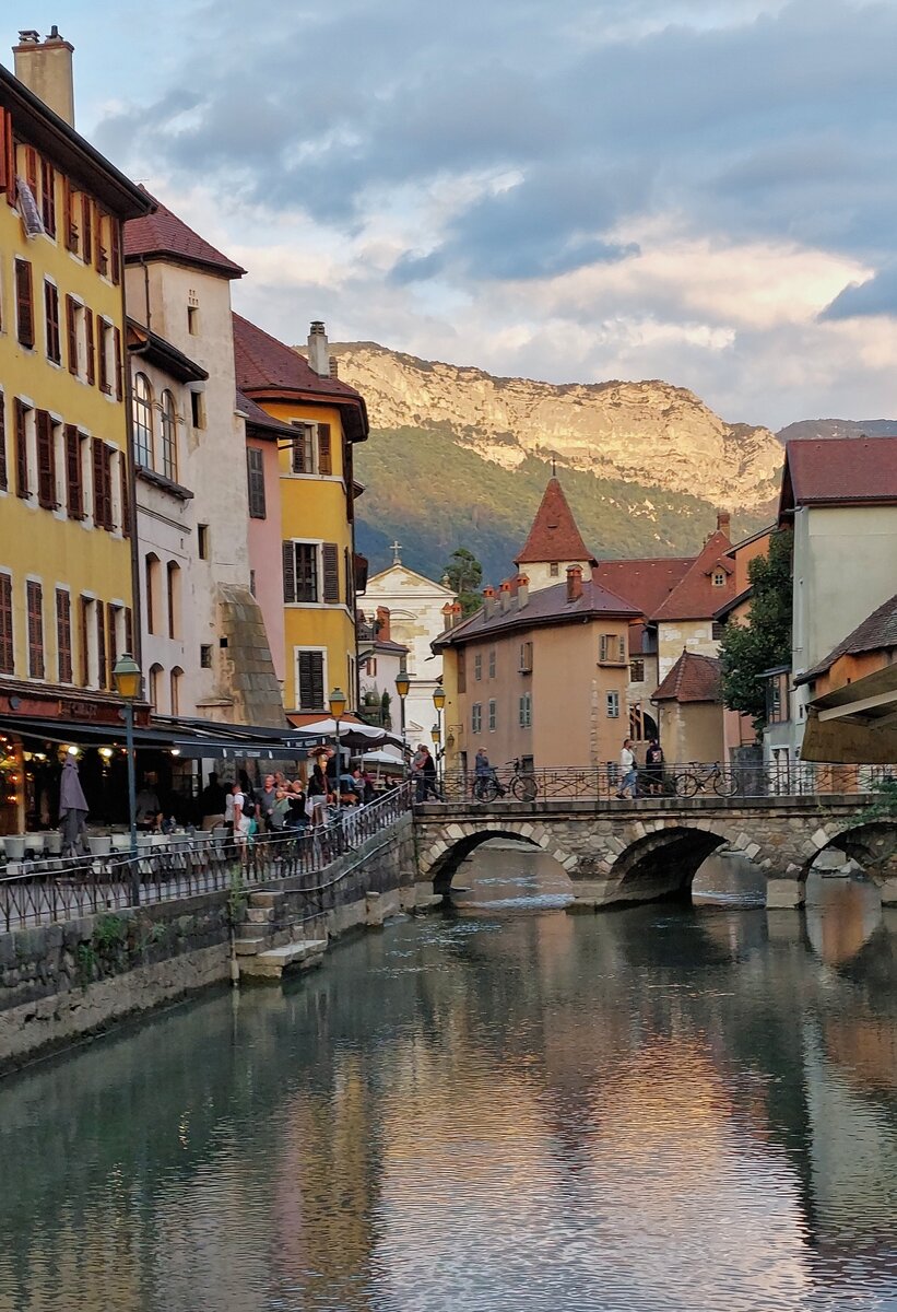 Impressionen aus der Altstadt von Annecy, der Fluß „Le Thiou“, vom See her kommend, die Altstadt und die Berge die den See umgeben, angestrahlt von der untergehender Sonne. 09.2022