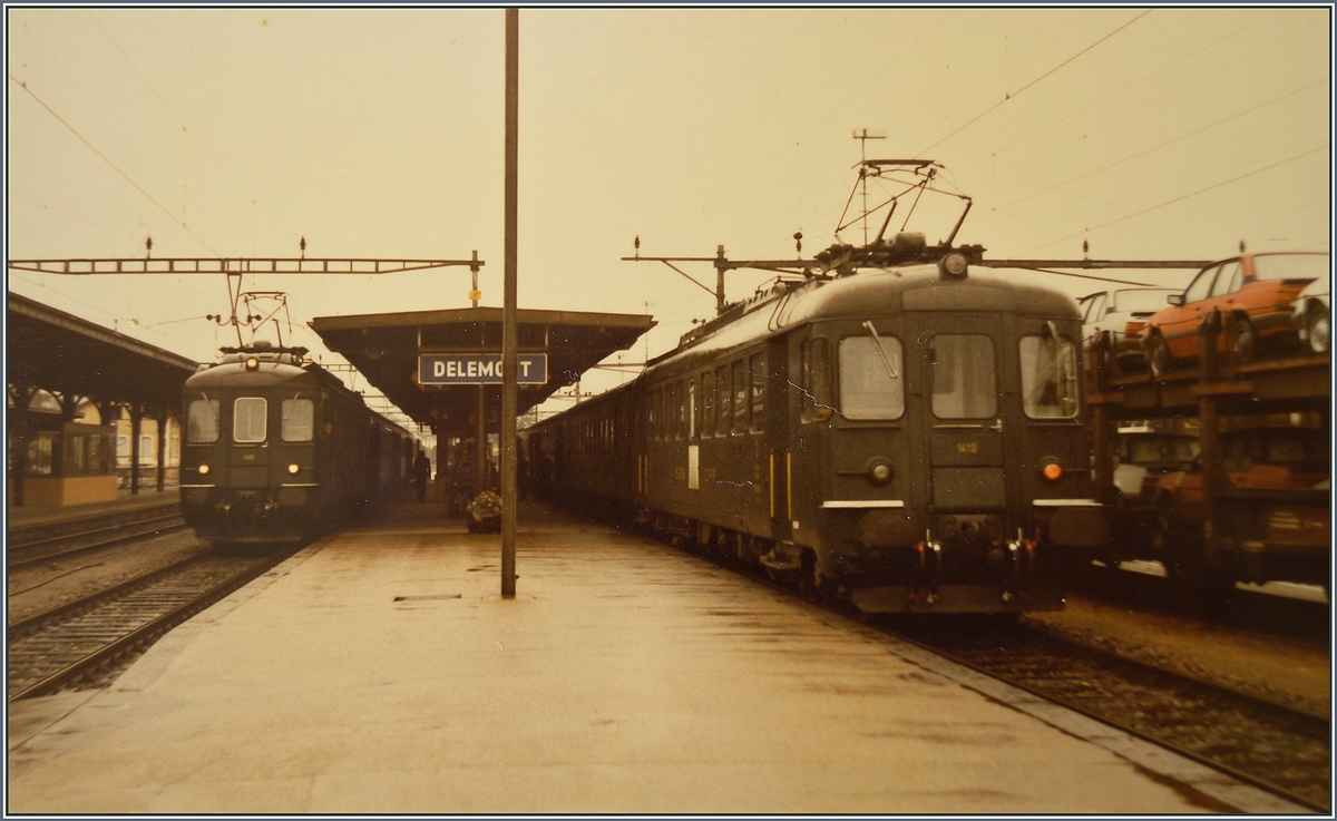 In Delémont warten zwei RBe 4/4 Pendelzüge auf die Abfahrt; interessant auch der Güterzug mit Neuwagen rechts im Bild, welcher wohl vom Peugeot Werk bei Montbéliard via Delle nach Delémont kam. 

16. Sept. 1984
