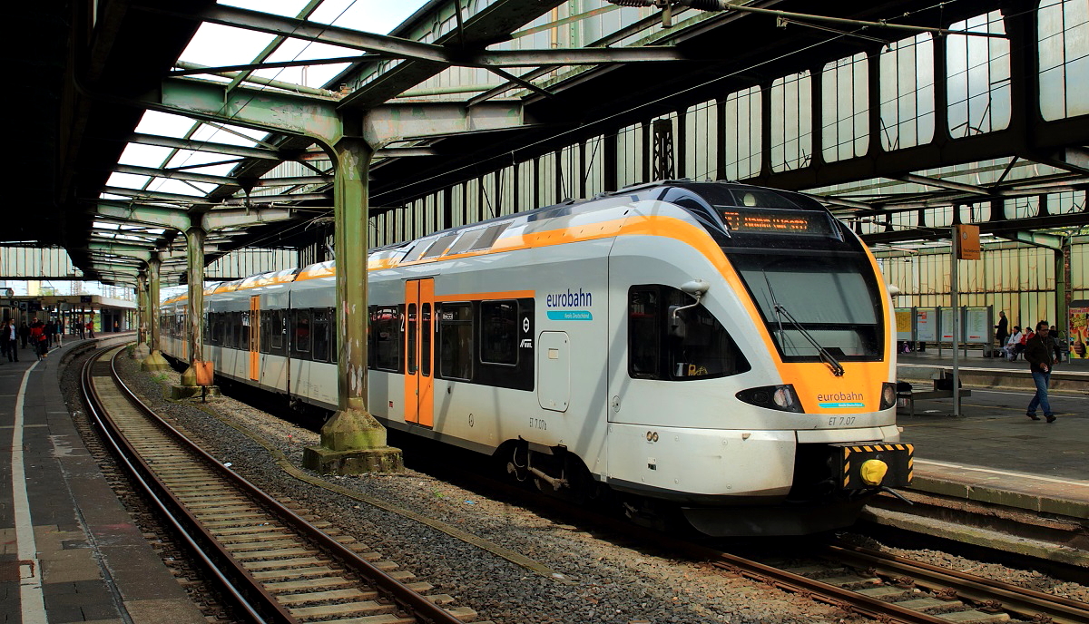 In diesem Jahr soll der Umbau des Duisburger Hauptbahnhofes beginnen. Dabei werden auch die aus den 1930er Jahren stammenden charakteristischen Hallendächer durch eine Neukonstruktion ersetzt. Davon ist aber noch nichts zu sehen, als der ET 7.07 der Eurobahn am 03.05.2017 auf Gleis 8 auf Fahrgäste nach Hamm (Westfalen) wartet.