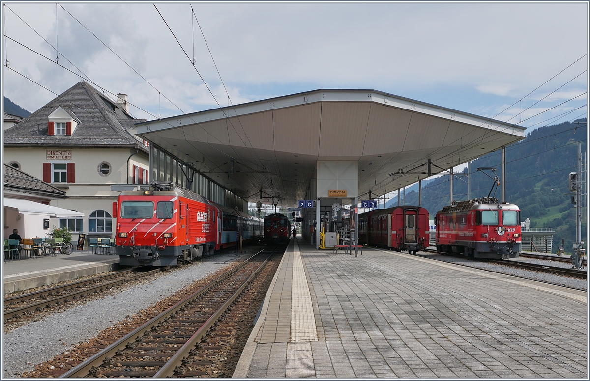 In Disentis hat die MGB HGe 4/4 II N° 4 die im Bild rechts zu sehende RhB Ge 4/4 II 629 vor dem Glacier Express abgelöst und wartet nun auf die Abfahrt in Richtung Zermatt. 

16. Sept. 2020