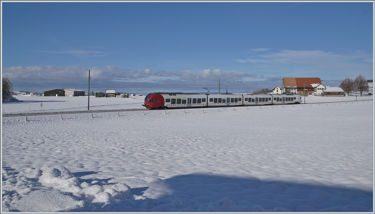 In der herrlich verschneiten Landschaft zwischen Sâles und Vaulruz fährt ein TPF RABe 527 in Richtung Bulle.

23. Dezember 2021