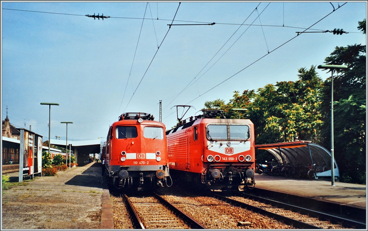 In Lörrach stehen: die DB 143 050-3 mit ihrer RB nach Basel Bad. Bf und die DB 110 470-2 mit ihrem  Schülerzug nach Freiburg i.B. (via weil am Rhein).

Analogbild vom August 2002