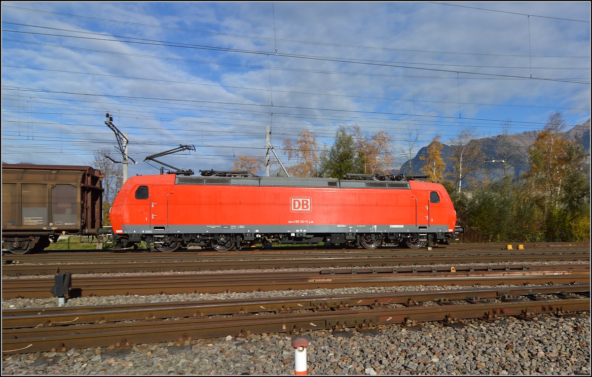 In Sargans passiert 185 141-9 mit dem Red-Bull-Zug den Betrachter. Die Route Singen-Konstanz-Rorschach wird wenn möglich gemieden, da dort keine langen Güterzüge fahren können. November 2015.