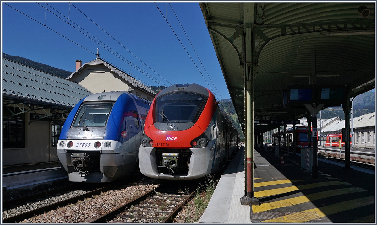 In St-Gervais Les Bains Le Fayet wartet der SNCF Z 27685 als TER 884662 auf die baldige Abfahrt nach Annemasse, während der SNCF Coradia Polyvalent régional tricourant Z 31517 M eine Stunde später als Léman Express L3 23482 nach Coppet fahren wird.

Rechts im Bild, leider nur angeschnitten, Triebzüge der Schmalspurban nach Vallorcine (-Martigny) 

7. Juli 2020