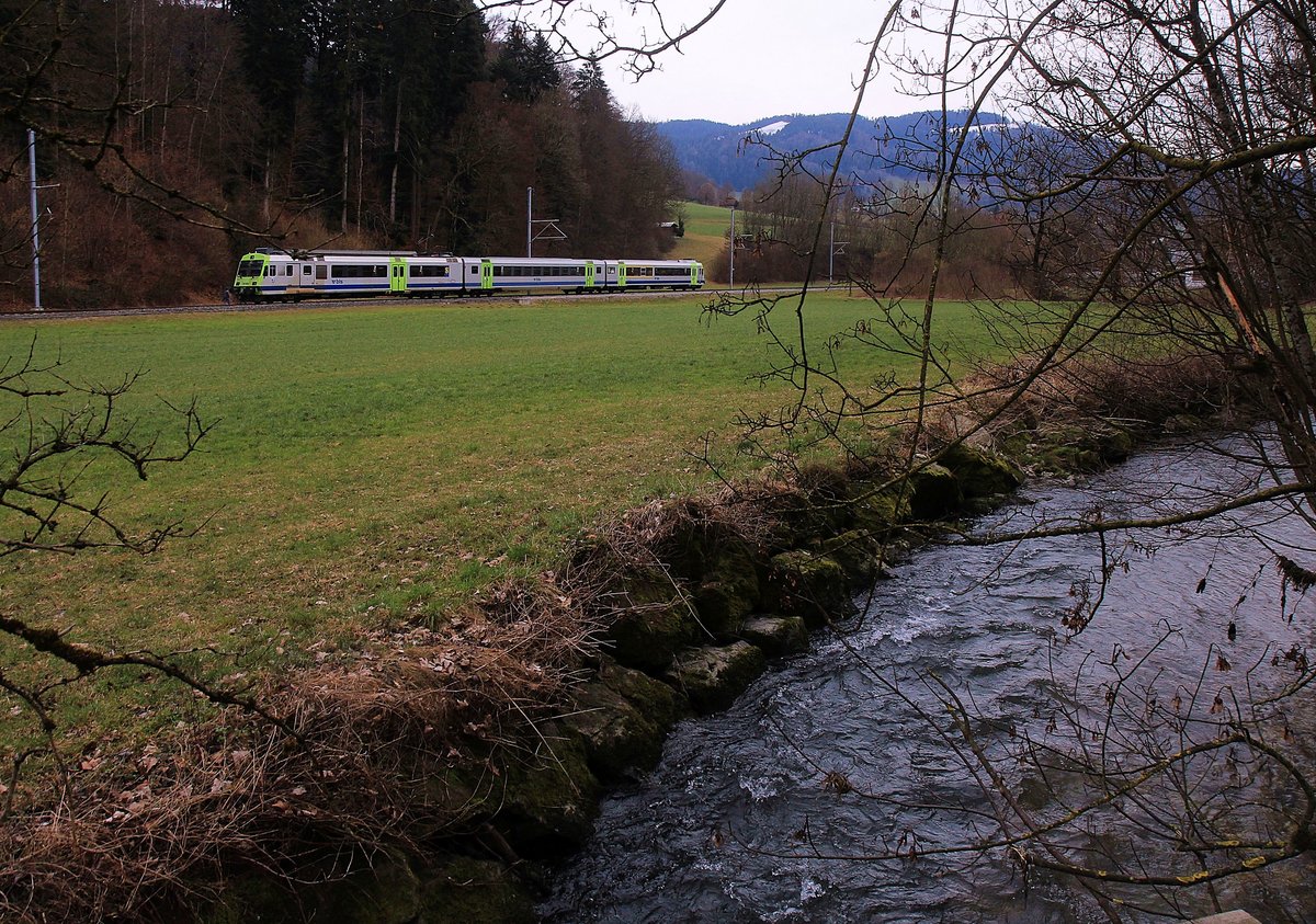 In der typischen Landschaft am Rande des Emmentals bei Oberdiessbach an der Lokallinie Burgdorf-Konolfingen-Thun fährt ein NPZ mit BLS-Triebwagen 235 durch. 16.Februar 2021 