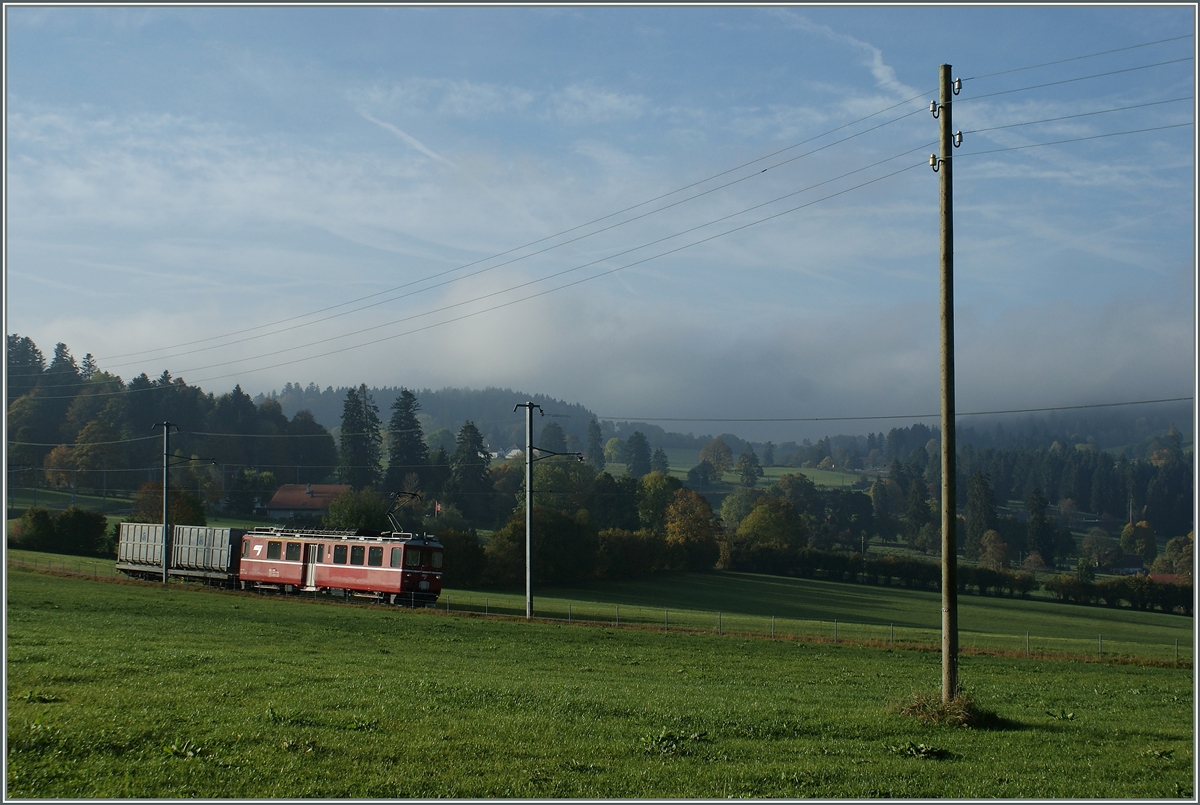 In der Weite der Juralandschaft ist bei La Cibourg ein ex RhB  Aroasbahn -Triebwagen mit einem Mll-Gterwagen untnerwegs.
11. Okt. 2010 