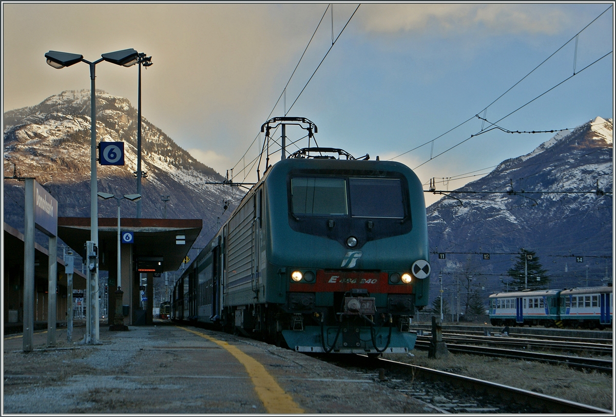 Kurz nach Tagesanbruch zeigt dies die FS E 464 240 in Domosossola. 
Links im Bild zeigen sich die Wolken, welche ein kräftiger Wind an die Alpennordseite drückt.
24. Jan. 2014