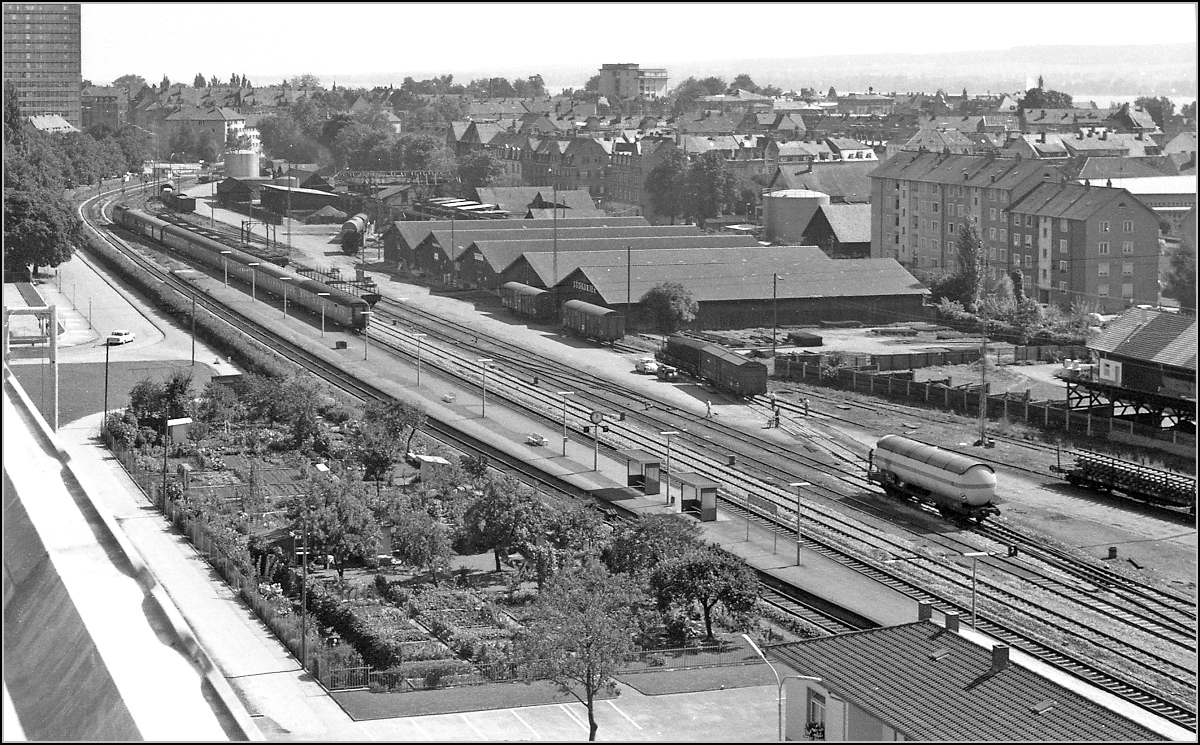 Letzte Station vor dem Grenzbahnhof. 1970 war im Bahnhof Petershausen noch Güterverkehr und reger Betrieb. Ein Eilzug aus Offenburg mit einer V 200 wartet auf Einfahrt nach Konstanz.
