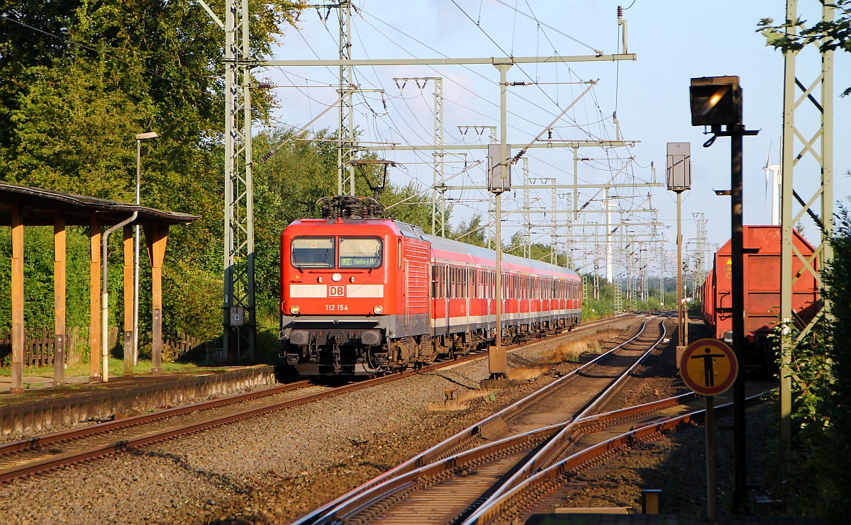 Links der SH-Express nach Hamburg mit Zuglok 112 154 bestehend aus 6 n-Wagen und rechts der wartende Holz-Leer-Zug im/am Bhf Jübek festgehalten. 14.08.2014