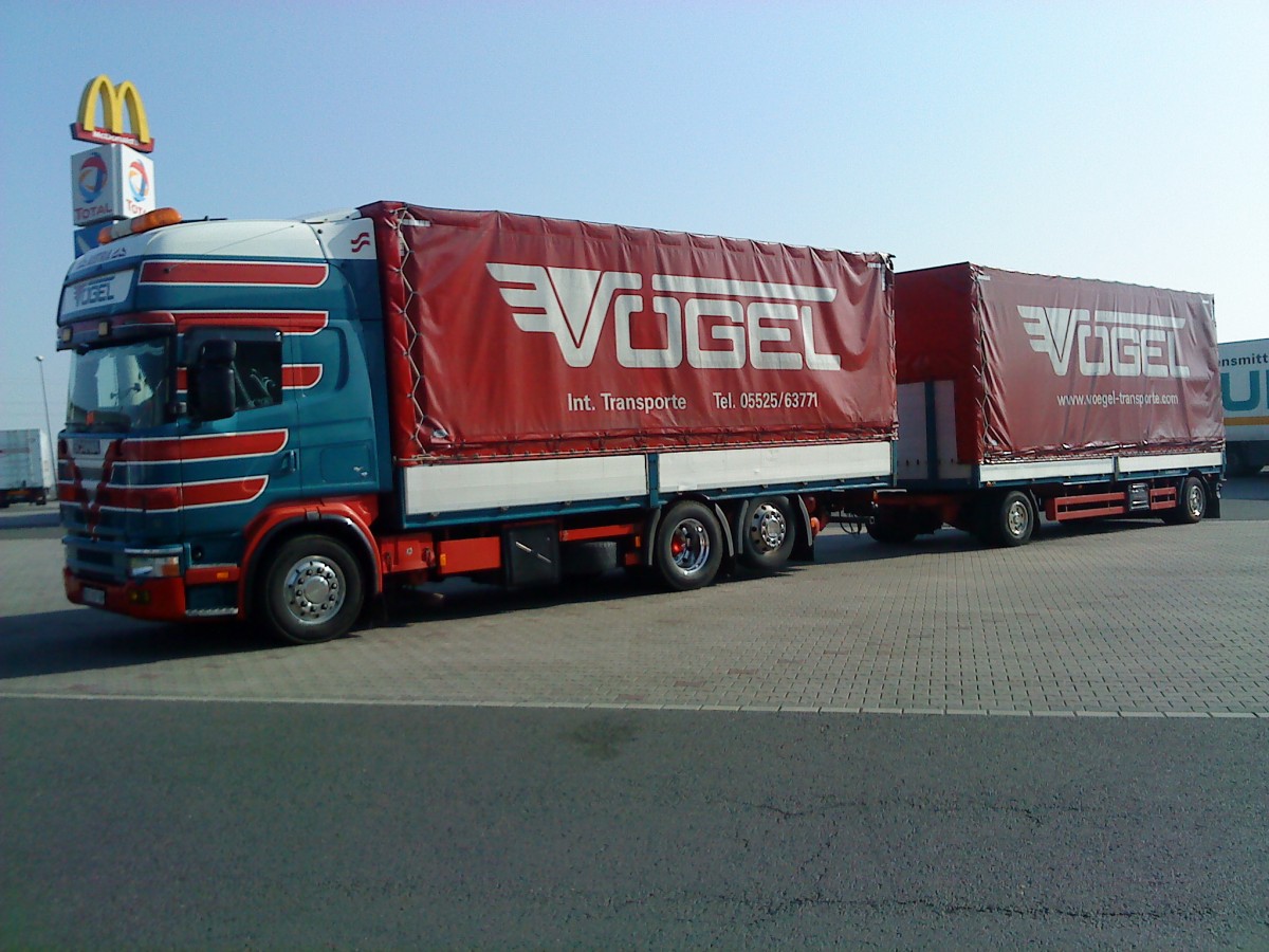 LKW SCANIA R 420 Hngerzug mit Pritsche-Planen-Aufbau der Spedition Vogel gesehen auf dem Autohof in Grnstadt am 12.03.2014