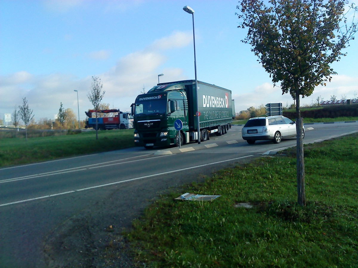 LKW SZM MAN TGX mit Pritsche-Planen-Auflieger der Spedition Duvenbeck beim Verlassen des Autohofes in Grnstadt am 30.10.2013