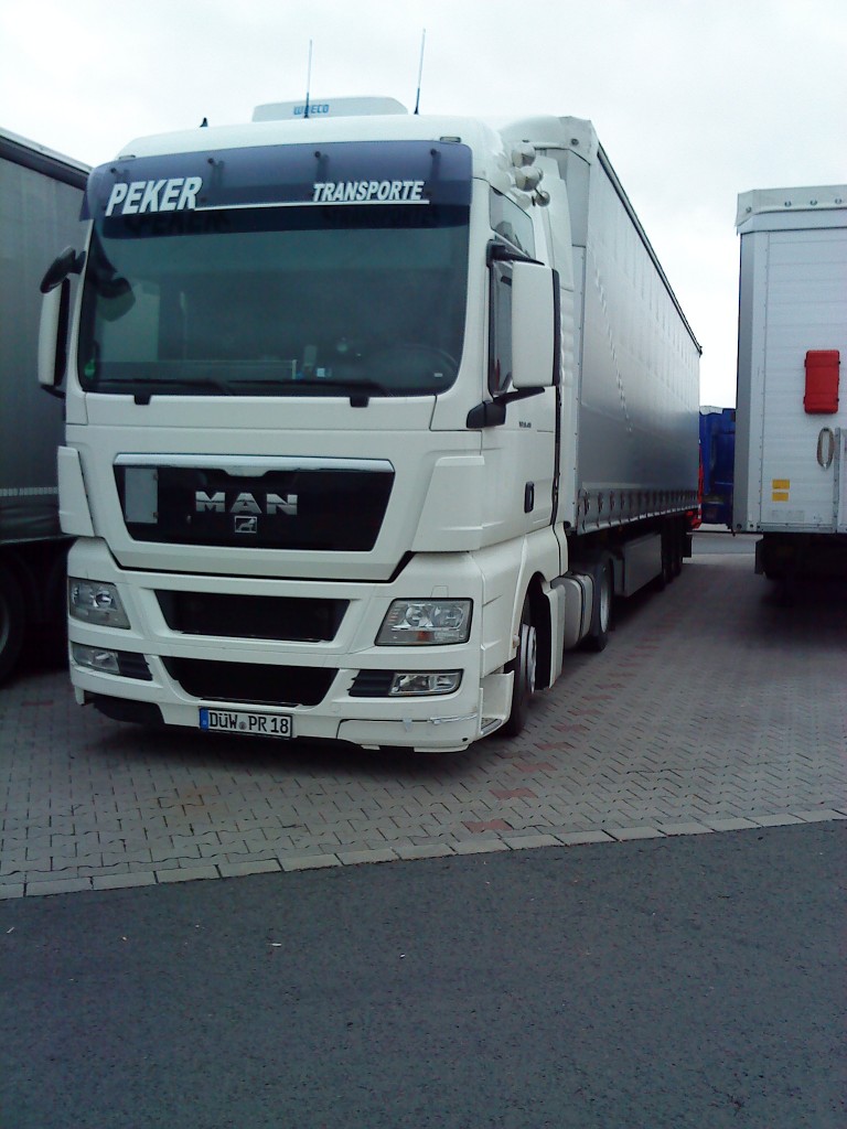 LKW SZM MAN TGX mit Pritsche-Planen-Auflieger der Spedition Peker auf dem AUtohof in Grnstadt am 06.11.2013