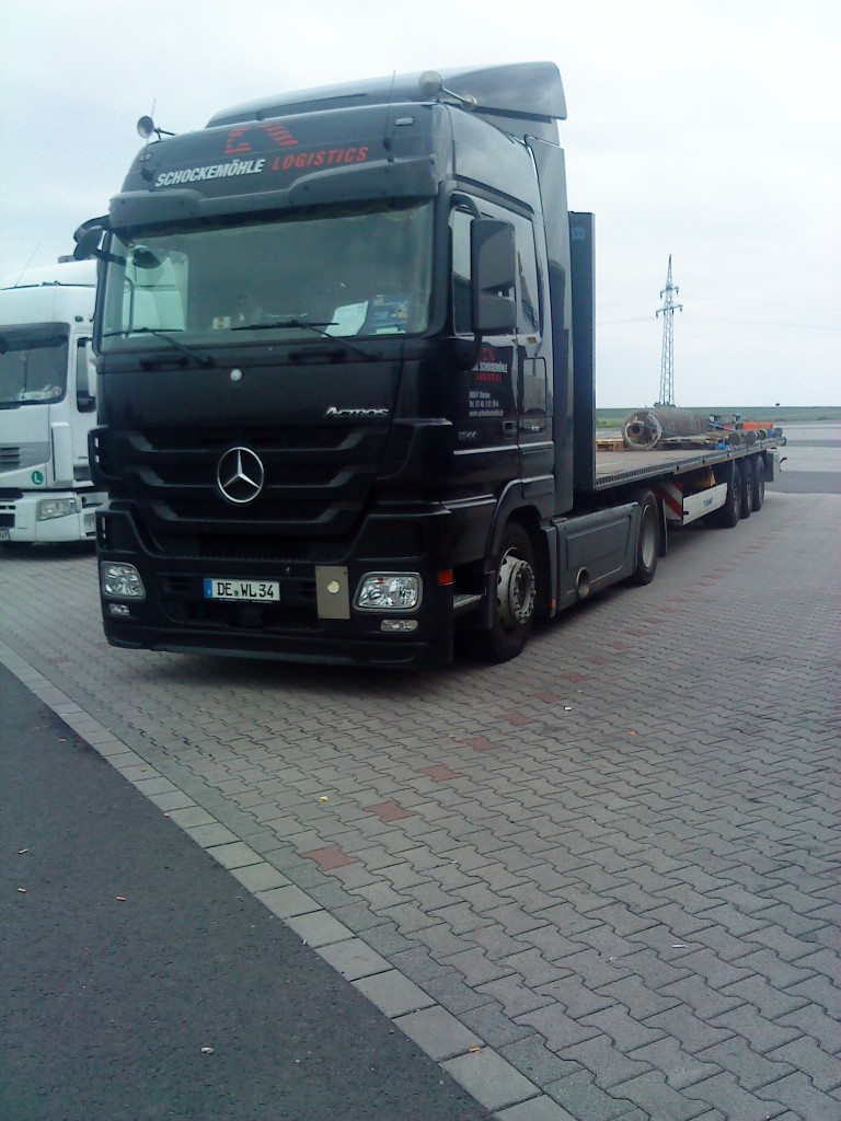 LKW SZM Mercedes-Benz Actros 1844 mit Plattformauflieger der Spedition Schockemhle Logistics auf dem Autohof in Grnstadt am 23.09.2013