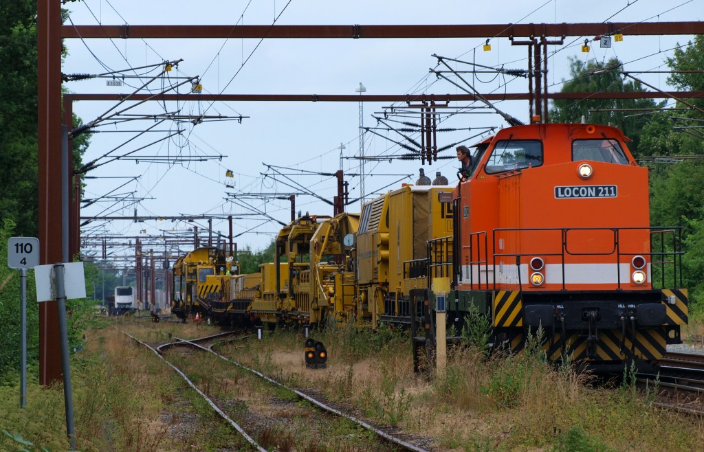 Locon 211(92 80 1293 502-1 D-LOCON) schiebt hier einen Bauzug( Bremen ) in den Güterbereich des Padborger Bahnhofes. 11.07.2010