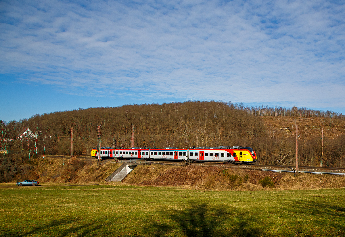 Man sieht nun auch vierteilige HLB  Grinsekatzen  auf der Dillstrecke....
Der ET 157 (94 80 1440 657-3 D-HEB / 94 80 1441 657-2 D-HEB / 94 80 1441 157-3 D-HEB / 94 80 1440 157-4 D-HEB) ein vierteiliger Niederflur-Elektrotriebwagen vom Typ Alstom Coradia Continental der HLB (Hessische Landesbahn), fährt am 02.03.2022 als RE 99 (Gießen - Siegen) und erreicht bald den Hp Rudersdorf (Kr. Siegen).

Der vierteilige Niederflur-Elektrotriebwagen wurde 2018 von ALSTOM Transport Deutschland GmbH in Salzgitter unter den Fabriknummer D041531-004 (A1, B, C und A2) gebaut und an die HLB geliefert. 

Die Triebzüge Alstom Coradia Continental gehören zur Fahrzeugfamilie modularer, niederfluriger elektrischer Nahverkehrs-Gliedertriebzüge Alstom Coradia. Die Züge werden aus einem Baukasten standardisierter Einzelfahrzeuge gebildet, die ihre technische Ausrüstung mit Ausnahme der Fahrmotoren auf dem Dach tragen. Die Endwagen tragen jeweils einen Haupttransformator, einen Antriebsumrichter und einen Nebenbetriebsumrichter. Die Mittelwagen tragen die weiteren Ausrüstungen Stromabnehmer, Kompressor und Batteriekasten. Mittig auf jedem Fahrzeug ist das Klimagerät für den Fahrgastraum angeordnet.

Die Hessische Landesbahn hat insgesamt 30 dieser neuen Niederflur-Elektrotriebzüge gekauft, 17 vierteilige und 13 dreiteilige ET. Am 27. Juli 2018 erhielten die Züge ihre Zulassung und werden seitdem Probebetrieb eingesetzt. Zudem wurden noch 5 weitere bestellt.

Die Züge erreichen im Einsatz Geschwindigkeiten von bis zu 160 km/h und besitzen ein sehr gutes Beschleunigungsvermögen. Sie können je nach Fahrgastaufkommen auch in Doppeltraktion betrieben werden. Durch ein speziell für Regionalzüge modifiziertes Zugsicherungssystem können die Fahrzeuge auch auf ICE-Strecken fahren. Die Triebzüge sind zudem mit elektrischen Bremsen ausgestattet, die in der Lage sind, beim Bremsvorgang bis zu 30 Prozent der Energie ins Netz zurück zu speisen.

TECHNISCHE DATEN der BR 1440.1:
Hersteller: Alstom Transport Deutschland GmbH
Spurweite: 1.435 mm
Achsfolge: Bo‘(Bo‘)(2’ )(Bo‘)Bo‘ in Klammern Jakobs-Drehgestelle
Länge über Kupplung: 73.300 mm
Breite: 2.920 mm
Drehzapfenabstände: 15.500 / 16.400 / 16.400 / 15.500 mm
Achsabstand im Enddrehgestell: 2.400 mm
Achsabstand im Drehgestell: 2.700 mm
Maximale Höhe (über SO): 4.280 mm
Eigengewicht: 144 t
Minimaler befahrbarer Gleisbogen Werkstatt/Betrieb: 100/150 m
Niederfluranteil: ca. 89 %
Sitzplätze: 227 (davon 12 in der 1. Klasse)
Stromsystem: 15 kV / 16,7 Hz
Höchstgeschwindigkeit: 160 km/h
Nennleistung: 2.900 kW
Anzahl Fahrmotoren: 8
Zugbeeinflussungs-System: LZB / PZB 90
