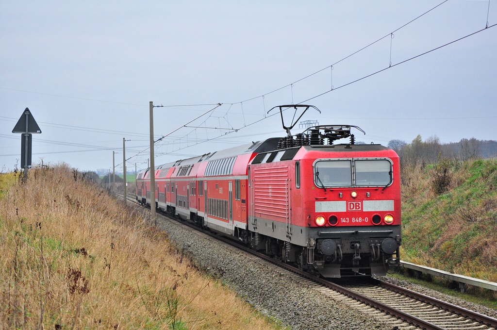 Mit dem Warnemünde-Express saust die 143 848 durch Gragetopshof ihrem vorletzten Halt Rostock Hbf entgegen.