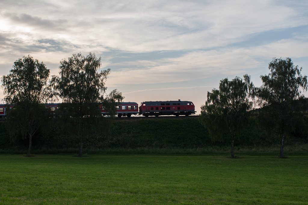 Mit einem kurzen Zug aus Bn-Wagen passierte am Abend des 10.06.14 eine 218 in Unterschwillach eine Lücke in einer kleinen Birkenallee. Ihr Ziel lautete Mühldorf.