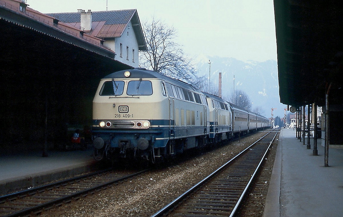 Mit einem schweizer Schnellzug fahren 218 409-1 und eine weitere 218 im April 1982 in Immenstadt ein