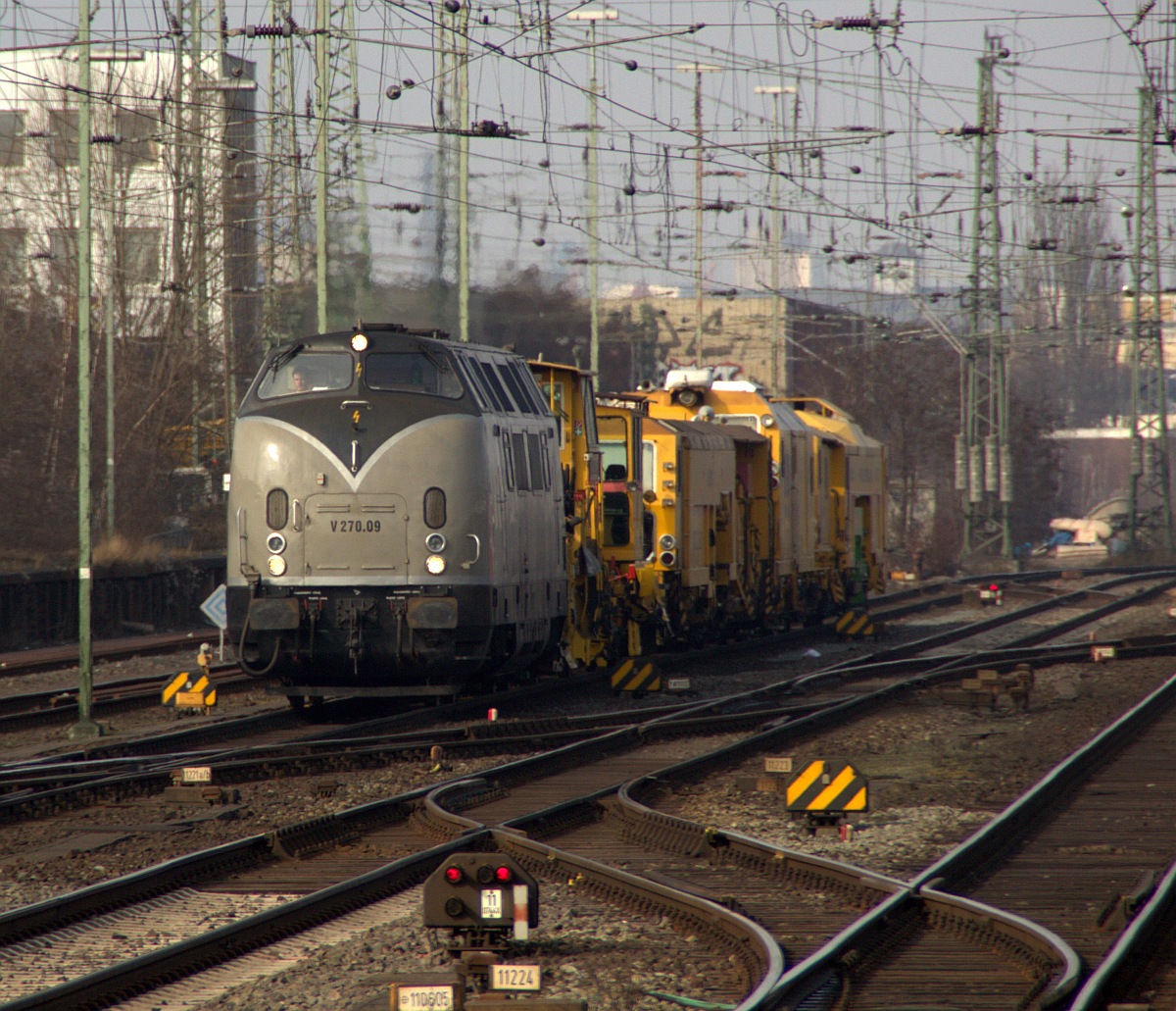 Mit lautem Pfiff dieselte die SGL V 270.09/221 121-7 mit einem Gleisbauzug durch den Bremer Hauptbahnhof. 03.03.2012