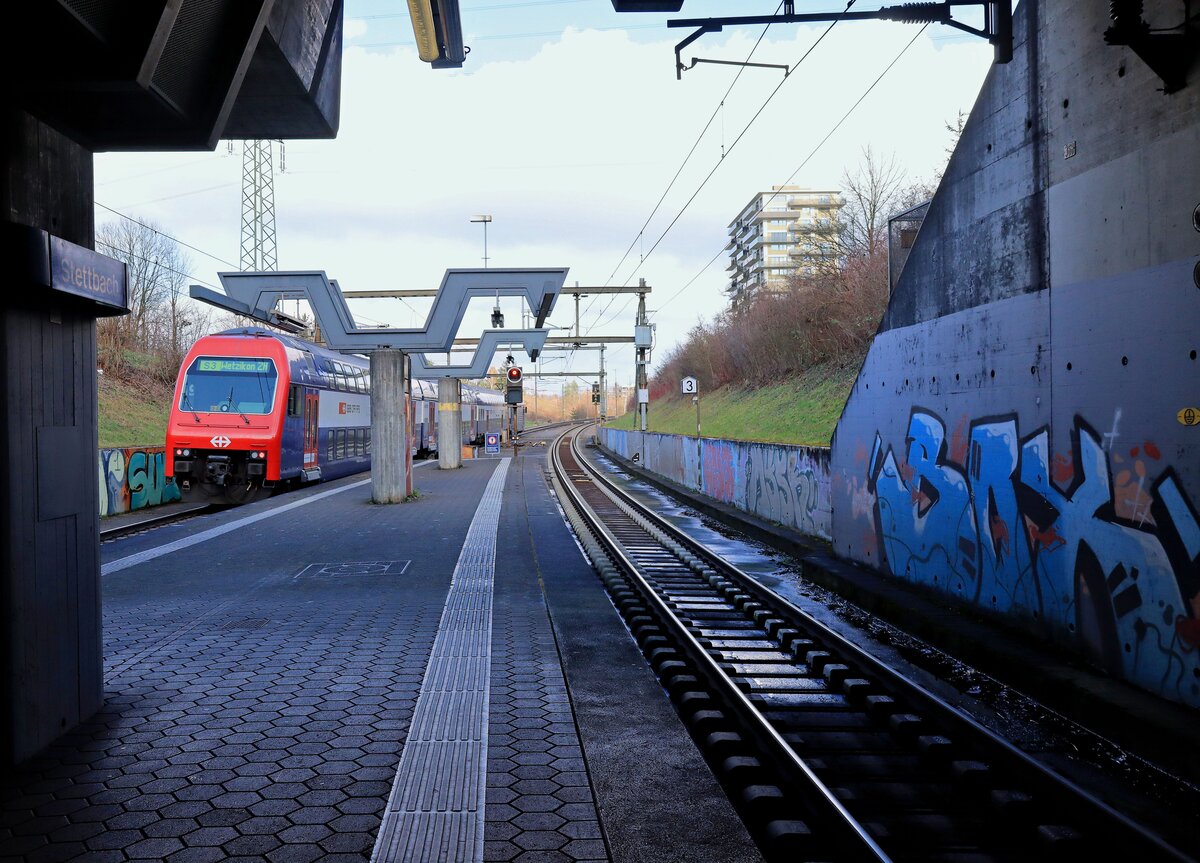 Mit der S-Bahn quer durch Zürich: Nach der Station Stadelhofen geht es für einige Linien durch den fast 5 km langen, 1990 eröffneten Zürichbergtunnel. In Stettbach kommt er wieder ans Tageslicht. Im Bild fährt ein Zug der S3 nach Wetzikon, geführt von Lok 450 006, aus dem Bahnhof Stettbach aus, einem Knotenpunkt mit dem Tram und der Glatttalbahn. 6.Februar 2023  