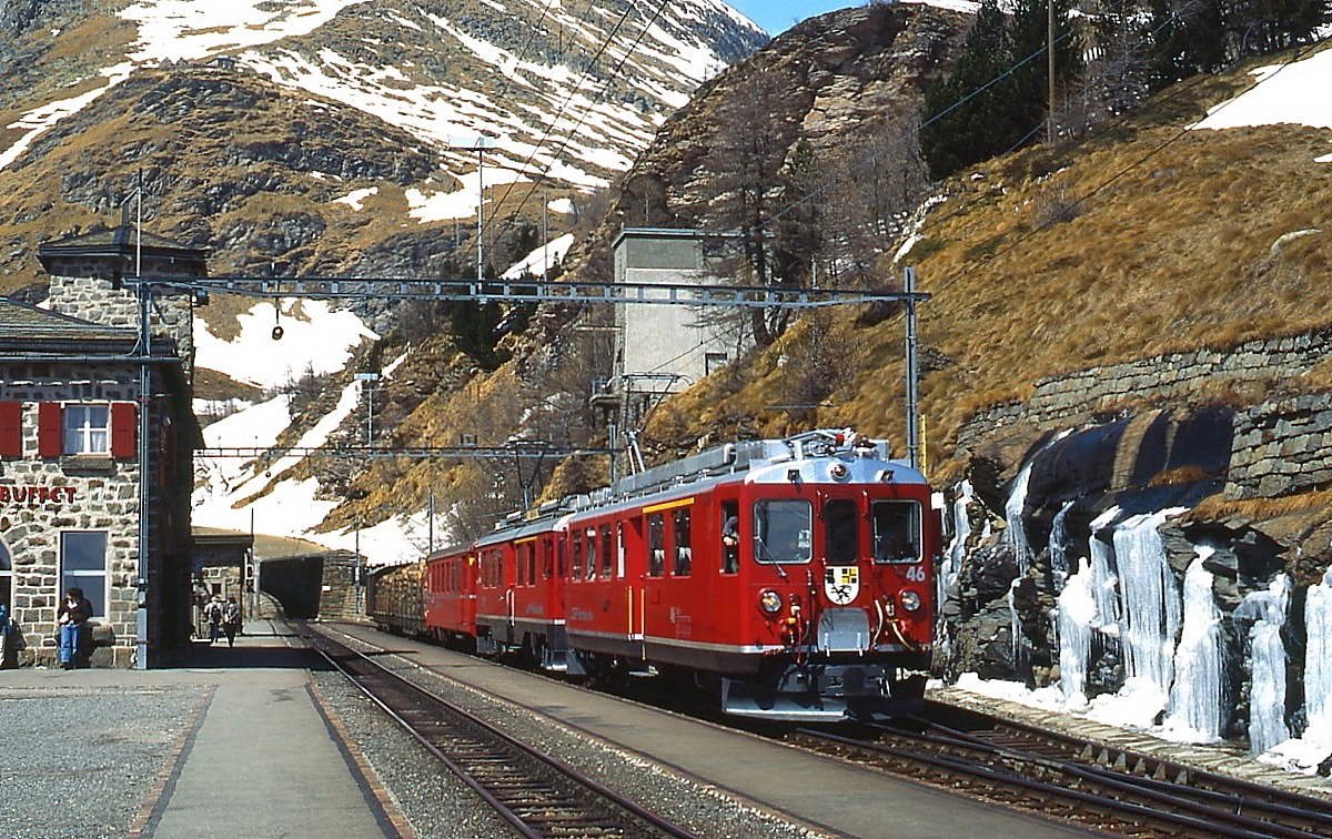 Mit zwei Holzwagen treffen der ABe 4/4 II 46 und ein weiterer ABe 4/4 II im April 1996 in der Station Alp Grm ein. Zwar ist der Schnee schon geschmolzen, doch das gefrorene Wasser zeigt, wie kalt die Nchte noch waren.