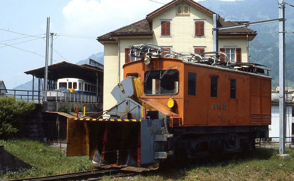 Nichts zu tun gibt es für die He 2/3 8 der Arth-Rigi-Bahn, die im Juli 1983 mit angebauter Schneeschleuder in Arth-Goldau abgestellt ist, im Hintergrund steht ein Zug auf die Rigi abfahrbereit im Hochperron des Bahnhofes Arth-Goldau
