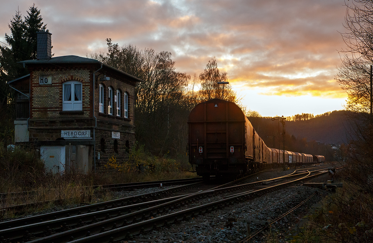 Nun fährt die KSW 42 (92 80 1277 902-3 D-KSW), eine Vossloh MaK G 1700 BB, am spätem Nachmittag des 24.11.2021, mit einem langen Übergabe-Güterzug (von Herdorf zum Rbf Kreuztal), von Herdorf los.