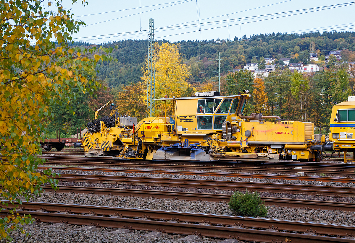 
Plasser & Theurer Schnell-Schotterverteil- und Planiermaschine SSP 110 SW, Schweres Nebenfahrzeug Nr. 99 80 9425 014-4 D-STRA, der STRABAG abgestellt am 23.10.2016 in Betzdorf/Sieg. Dahinter die STRABAG Tauberexxpress eine Stopfexpress CSM 09 – 3X, Schweres Nebenfahrzeug Nr. 99 80 9121 004-2 D-BRS.

Ausrüstung:

- Schottersilo mit 5 m³ Volumen
- hydraulisch verstellbare Schottersilohosen  innen und außen zur Verteilung des Schotters in die Stopfzonen
- Ersatzbesenschwellen für B70 normal, B70 tief und Weichenschwellen
- Kleineisenbürsten
- Querförderband zur Verteilung des überzähligen Schotters nach rechts und links
- höhenverstellbare Bürstenwelle
- Linienleiterabdeckung für Kehrbesen
- Panoramakomfortkabine zur besseren Bedienung


Technische Daten:
Hersteller: Plasser & Theurer
Baujahr: 2011 (Fabriknummer 911)
VDM-Nr.: 99 80 9425 014-4 D-STRA

Motor: wassergekühlter Deutz-Dieselmotor BF 8 M 1015 C, 
aktiver  Rußpartikelfilter
Leistung: 400  kW
max. Geschwindigkeit in Eigenfahrt: 100 km/h
max. Geschwindigkeit in Schleppfahrt: 100 km/h
Eigenfahrtrichtung: beidseitig
Achsanzahl:  2
Sifa / PZB / Zugbahnfunk  (analog /digital):  Ja
Arbeitsgeschwindigkeit: bis 3.000 m/h (Gleis)
Arbeitsweise: kontinuierlich
min. Radius bei Arbeit: 180 m
min. Radius bei Fahrt: 120 m

Fahrzeug: 
Zulassung:  gemäß Richtlinien EBA/DB AG §32
Spurweite: 1.435  mm
Eigengewicht:  43.000 kg
Höhe: 4.255  mm
Breite: 3.000  mm
Länge über Puffer: 17.225 mm
Achsabstand: 8.100 mm
Kraftstoffvorrat (Diesel): 1.040 l
Streckenklasse: D 4 oder höher
