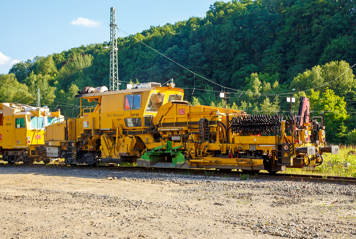 
Plasser & Theurer  Universalschotterplaniermaschine USP 2000 SWS (Schweres Nebenfahrzeug Nr. 97 16 32 004 17-4)  SSP 682 „Hot Sweeper“ der DB Bahnbau Gruppe, am 14.06.2017 in Betzdorf/Sieg abgestellt. Ehemals gehörte die Maschine der DB Netz AG, Maschinenpool (Netz Instandhaltung).

Die Universalschotterplaniermaschine (Schotterpflug) mit der internen DB Bezeichnung SSP 682 wurde 2001 von Plasser & Theurer unter der Fabriknummer 711 gebaut.

Die Maschine ist mit zwei 2-achsigen Drehgestellen für Gleise und Weichen mit Schottersilo, ausgestattet mit einem geteilten Mittelpflug. Geeignet zum Pflügen in Gleisen mit Linienleiter, wobei der Schotterfluss über einen Symboltaster genau dosiert werden kann. Der Flankenpflug bringt den Schotter aus dem Bereich der Bettungsflanke zur Bettungskrone. Kehrvorrichtung mit reversiblem Querförderband zur Ablagerung des überschüssigen Schotters an einer Bettungsflanke. Steilförderband, Schottersilo mit Bodenförderband und Verteileinrichtungen dienen zur Speicherung und Wiedereinbringung von Schottermaterial. Hydrostatischer Fahrantrieb auf allen Achsen, UIC-Bremsen, Großraumkabine mit Führerständen und Frontscheiben aus Sicherheitsglas. 

Der richtig definierte Bettungsquerschnitt ist vor allem für die Sicherung der Gleislage gegen Verwerfungen wichtig. Die richtige Verteilung des Schotters im Gleis sowie die Rückgewinnung von der Flanke ist ein Faktor höchster Wirtschaftlichkeit. Die Bearbeitung der Bettungsoberfläche, insbesondere an den Flanken, wirkt sich auch günstig gegen Pflanzenbewuchs im Bettungsbereich aus. Dabei handelt es sich in erster Linie um eine rein mechanische Beeinflussung der Schotteroberfläche. Auf Schnellfahrstrecken ist die Bearbeitung der Schwellenoberflächen und der Zwischenfächer durch gründliches Abkehren wichtig, um das Aufwirbeln von Schottersteinen aufgrund der hohen Geschwindigkeiten zu verhindern

TECHNISCHE DATEN:
EBA-Nummer: EBA 00 A 11 003
Spurweite: 1.435 mm (Normalspur)
Anzahl der Achsen: 4
Länge über Puffer:  19.000 mm
Drehzapfenabstände: 11.500 mm 
Achsabstand im Drehgestell: 1.800 mm / 1.500 mm
Raddurchmesser (neu): 730 mm
Eigengewicht: 54,000  kg
Nutzlast: - t
Zul. Anhängelast: 40 t
Leistung: ca. 400 kW 
Zur Mitfahrt zugel. Personenzahl: 2
Kleister befahrbarer Gleisbogen: R = 120 m
Zugelassen für Streckenklasse: B1 und höher
Höchstgeschwindigkeit: 100 km
Bremse: KE-GP mZ K
Bremsgewichte: G 37 t / P 38 t