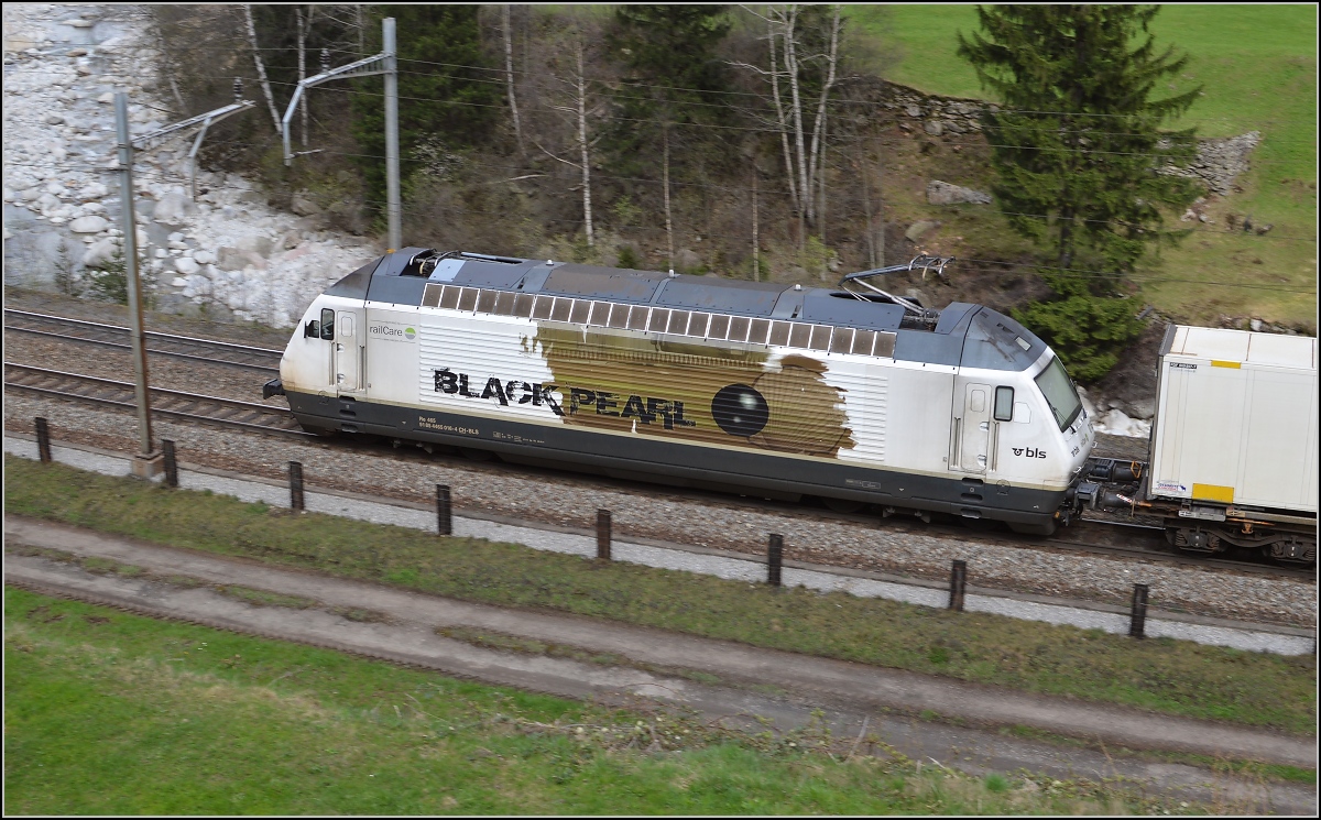 Re 465 016-4 der BLS, vermietet an Railcare, kommt den Gotthard hinuntergefahren. Wassen, April 2016.