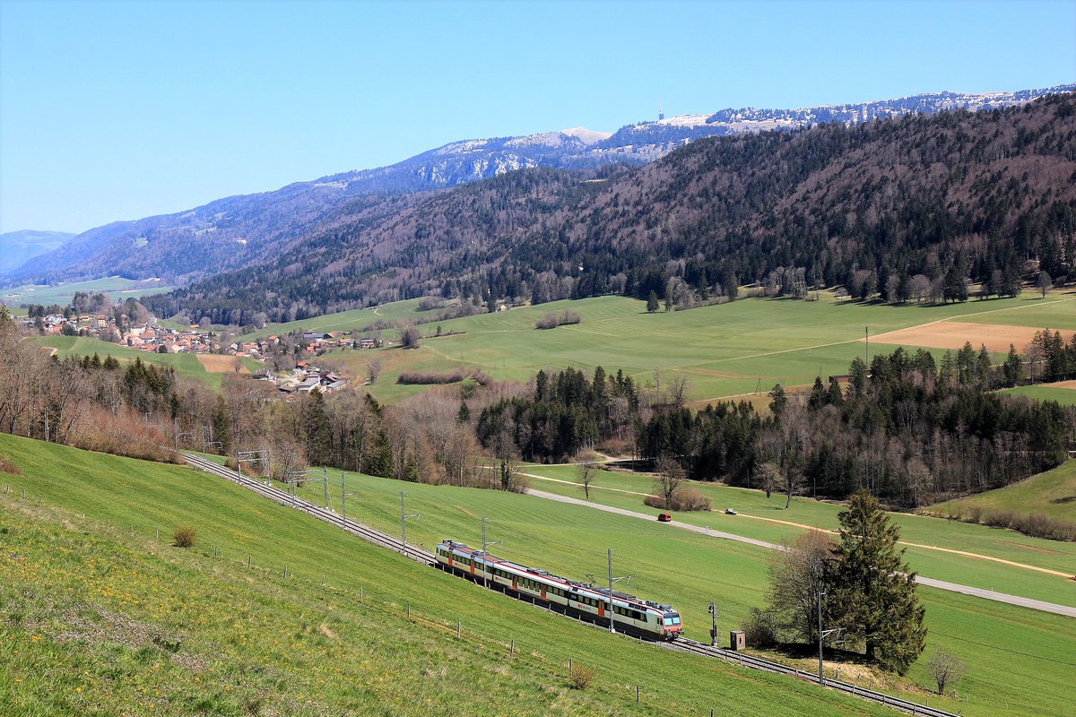Renan (Kanton Bern). Ein NPZ-Domino-Zug unterwegs talabwärts zwischen Renan und Sonvilier, mit Blick auf den 1607 Meter hohen Chasseral. 23.April 2021 