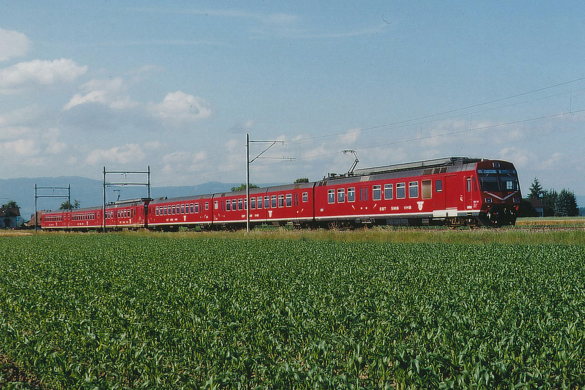 RM: Anlässlich des Eidgenössischen Jodlerfestes vom 22. bis 24. Juni 1990 in Solothurn wurden die Züge zwischen Solothurn und Burgdorf verstärkt. Der 6Wagenzug mit zwei RBDe 566 wurde zwischen Utzenstorf und Aefligen verewigt (24. Juni 1990).
Foto: Walter Ruetsch