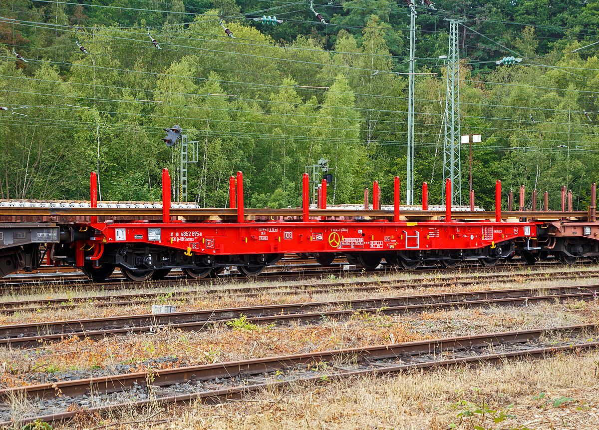 Sechsachsiger Drehgestell-Flachwagen, mit Rungen, Stirnwandklappen und klappbaren Ladeschwellen, jedoch ohne Seitenwandklappen, 31 80 4852 895-6 D-DB, der Gattung Samms 489.1, der DB Cargo AG, abgestellt am 09.08.2019 im Zugverband, beladen mit Langschienen, am 09.08.2019 im Rbf Betzdorf (Sieg).

Der Wagen war sehr neu, er wurde 2019 von Tatravagonka a.s. in Poprad (Slowakei) unter der Fabriknummer 036 gebaut. Zusammen mit Stahlkunden entwickelt die DB Schenker im Jahre 2007 einen neuen Flachwagen, der auf die Bedürfnisse der Branche noch besser eingeht. Gebaut wurden sie von dem slowakischen Hersteller Tatravagonka Poprad, die DB Cargo hatte 225 Wagen bestellt.

Der Wagen dient mit aufgeklappten Ladeschwellen zur Beförderung von schweren Walzprofilen und anderen sperrigen Gütern. Mit eingeklappten Ladeschwellen, also mit ebener Ladeebene, eignet er sich auch zum Transport schwerer Kettenfahrzeuge. Für das Be- und Entladen solcher Fahrzeuge sind befahrbare Stirnwandklappen vorhanden. Die Wagenbrücke ist eine in Rahmenbauweise ausgeführte Schweißkonstruktion, deren Hauptbauteile aus S355J2 (St 52) bestehen. Die Hauptbelastungen werden von den äußeren Langträgern aufgenommen. Das Kopfstück und Untergestell sind so ausgebildet, dass später ohne große Änderungen die AK eingebaut werden kann. Der Fußboden besteht aus Kiefernbohlen mit den Abmessungen 70 x 200 mm; er kann eine Radlast von 5,0 t aufnehmen. Im Fußboden sind 6 geteilte klappbare Ladeschwellen eingebaut, ebenso 6 Zurrpunkte je Längsseite. An den Außenlangträgern sind 26 Bindeösen angebracht.

Das Fahrzeug hat auf jeder Längsseite 6 Einsteckrungen und 6 zusätzliche Rungenschächte, wodurch eine variable Platzierung der Rungen ermöglicht wird (anders als bei den Vorgänger-Modellen). An jeder Stirnseite gibt es je 2 versenkbare Rungen (Fallrungen). Die Stirnwände sind umklappbar.

Die Tragfähigkeit konnte im Vergleich zu anderen Wagen der Bauart Samms auf 104 Tonnen gesteigert werden, weshalb bis zu 20 Prozent Wagenresourcen eingespart und die Transportkette optimiert werden kann. Durch den Einsatz der Kunststoff-Bremssohle (Cosind 810) fährt der Wagen lärmreduziert.

TECHNISCHE DATEN:
Gattung: Samms 489.1 (Gattungskennzahl 4852 / 4858)
Spurweite: 1.435 mm (Normalspur)
Länge über Puffer: 16.400 mm
Drehzapfenabstand: 9.150 mm
Radsatzstand in den Drehgestellen: 2 x 1.700 mm = 3.400 mm
Raddurchmesser: 920 mm (neu)
Drehgestell-Typ: BA 714.3
Ladelänge: 15.000 mm
Ladebreite: 2.630 mm (zwischen den Rungen)
Fußbodenhöhe über SO: 1.300 mm
Ladefläche: 46 m²
Eigengewicht: 31.000 kg
Zuladung bei Lastgrenze S: 74,0 t (ab Streckenklasse D2)
Zuladung auf DB Netz bei Streckenklasse CE/D: 89 t (max.100 km/h)
Max. Zuladung: 104 t
Max. Geschwindigkeit: 100 km/h (beladen) / 120 km/h (leer)
Kleinster Gleisbogenhalbmesser: 75 m
Bauart der Bremse: KE-GP-A (K) max. 88 t
Bremssohle: Cosid 810
Handbremse: Ja
Internationale Verwendungsfähigkeit: TEN-GE
