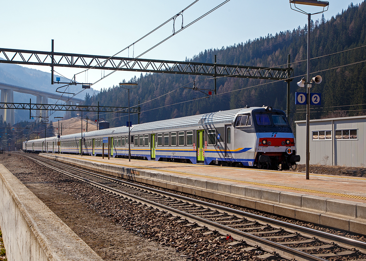 Sehr sauber und Steuerwagen voraus erreicht der Trenitalia Regional-Express RE 3462 (Verona Porta Nuova – Trento – Bozen – Brenner/ Brennero) am 27.03.2022 den Bahnhof Gossensaß/Colle Isarco, Schublok war die E.464.562.

An der Spitze ein 2. Klasse Reisezug- MDVC-Steuerwagen mit Gepäckabteil (MDVC steht für Medie Distanze Vestiboli Centrali, deutsch für Mittlere Entfernungen in Ballungsräumen) der Gattung npBD. Bei diesen Wagen handelt es sich um in Italien hergestellte Eisenbahnwaggons die speziell für den Einsatz für mittlere Entfernungen wie z.B. RE (Regionalexpress Züge). Das „TE“ (vorne unten zeigt das es sich um einen Steuerwagen vom Typ TE (Tipo TE) für E-Loks handelt.
