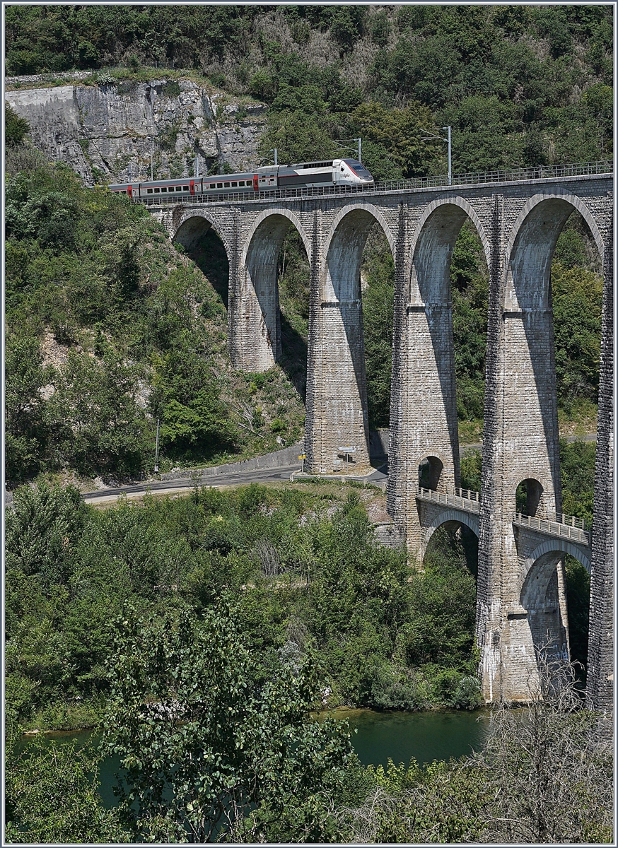 Seit Ende 2010 nehmen die TGV Züge von Genève nach Paris den weg über die dafür hergerichtet Strecke Bellegarde - Nantua - Bourg en Bresse, die zwar keine hohen Geschwindigkeiten erlaubt, aber dann der eingesparten 47 km gegenüber der Strecke via Culoz doch eine erhebliche Zeitersparnis bringt. Im Bild der TGV-Triebzug 4401 als TGV Lyria 9770 von Genève nach Paris welcher den 269 Meter langen Viaduc de Cize-Bolozon verlässt und im  1686 Meter langen Tunnel von Racouse verschwindet. 

17. Juli 2019