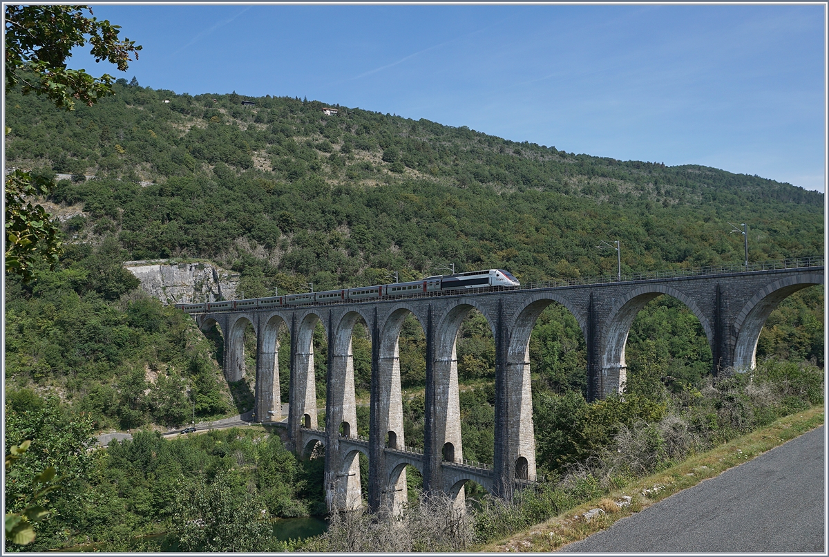 Seit Ende 2010 nehmen die TGV Züge von Genève nach Paris den Weg über die dafür hergerichtet Strecke Bellegarde - Nantua - Bourg en Bresse, die zwar keine hohen Geschwindigkeiten erlaubt, aber dann der eingesparten 47 km gegenüber der Strecke via Culoz doch eine erhebliche Zeitersparnis bringt. Im Bild der TGV-Triebzug 4415 als TGV Lyria 9765 von Paris nach Genève den Racouse Tunnel verlassen hat und nun auf dem 269 Meter langen Viaduc de Cize-Bolozon über die Ain fährt. 

17. Juli 2019