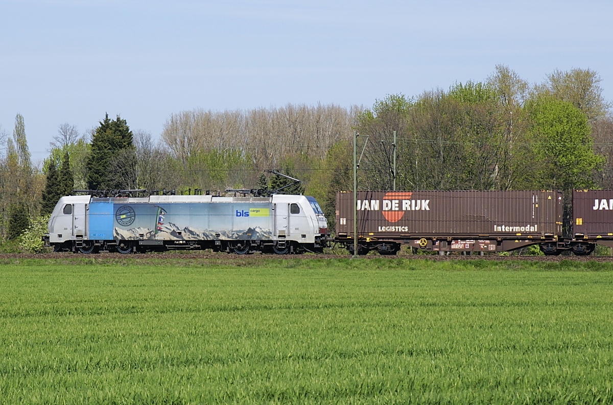 Seitenansicht der z. Zt. von BLS Cargo eingesetzten Railpool-186 185-3, die am 23.04.2021 bei Neuss in Richtung Norden fährt