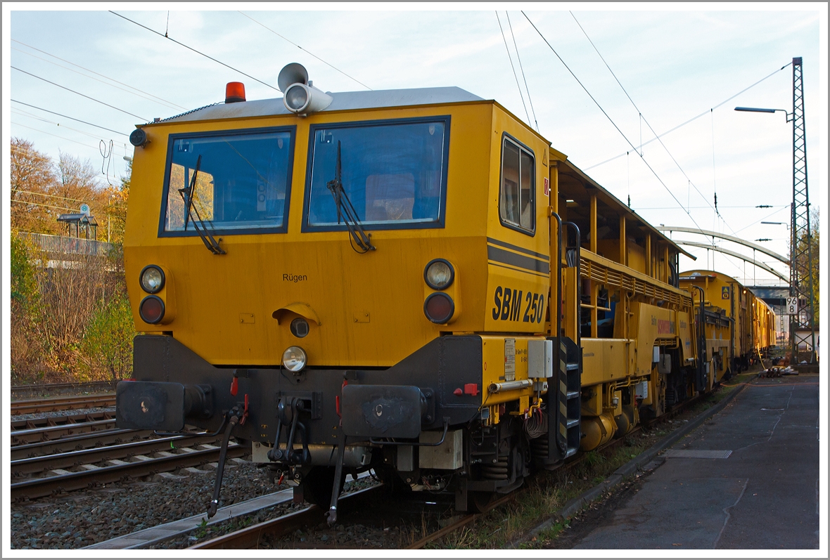 Sieht aus wie eine Stopfmaschine, ist es aber nicht, denn es ist...
Die Plasser & Theurer Schienenbearbeitungsmaschine SBM250 (Schienen-Hobelmaschine) der Schweerbau, Schweres Nebenfahrzeug Nr. 97 33 20 501 17-2, abgestellt am 16.11.2013 in Kreuztal.

Fr die Beseitigung sehr groer Schienenfehler und zur Beseitigung von Spurverengungen ist die Hobelmaschine SBM 250 nach wie vor die technisch beste und gnstigste Lsung.

Die Maschine wurde von Plasser & Theurer  1993 unter der Fabriknummer 48 gebaut.

Technische Daten:
Eigengewicht: 95 t
Zul. Anhngelast: 40 t
Lnge ber Puffer:  28.940 mm  
Hchstgeschwindigkeit: 90 km/h
Zur Mitfahrt zugel. Personen: 6
Zugelassene fr Streckenklasse: C2 und hher
