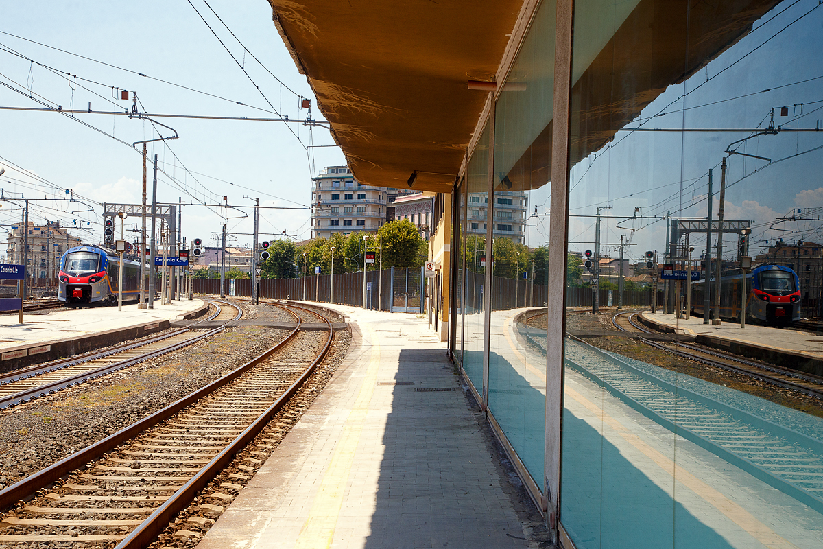 Spiellein an der Wand, wer ist der schönste im Land....
Der Trenitalia „pop“ ETR 104 083, ein vierteiliger Alstom Coradia Stream, verlässt am 20.07.2022 den Bahnhof Catania Centrale in Richtung Bicocca bzw. Syrakus (Siracusa).

Beim Alstom Coradia Stream handelt es sich um einen für den europäischen Markt entwickelten elektrischen Niederflurtriebzug für den Regional- und Intercity-Verkehr. Die Trenitalia erteilte Alstom im August 2016 einen Rahmenauftrag zur Lieferung von 150 Coradia-Zügen. Der Coradia Stream wird von der italienischen Eisenbahngesellschaft „Pop“ genannt und wird in verschiedenen italienischen Regionen eingesetzt. Er soll modular aufgebaut und damit einfacher für verschiedene Bedürfnisse anpassbar sein. Diese Lösung wird an verschiedene Konfigurationen und Kapazitätsanforderungen für den Regional- und Nahverkehr angepasst. 

Alle Coradia Stream für die Trenitalia werden in Italien in den Werken in Savigliano, Sesto San Giovanni und Bologna gefertigt.

TECHNISCHE DATEN:
Bezeichnung: ETR.103 (3-Teiler) / ETR.104 (4-Teiler)
Spurweite: 	1.435 mm (Normalspur)
Achsformel: Bo'(2')(2')Bo' (ETR 103) / Bo'(2')(2')(2')Bo' (ETR 104)
Länge über Puffer: 65,7 m (ETR 103) / 84,2 m (ETR 104)
Höchstgeschwindigkeit: 160 km/h
Leistung: 2.000 kW
Stromsystem: 3.000 V DC (=)
Sitzplätze: 	239 (ETR 103) / 321 (ETR 104)
