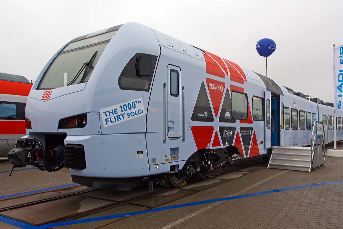 
Stadler Pankow präsentiert den 1. FLIRT der 3. Generation für die DB Regio AG, auf der InnoTrans 2014 (hier 26.09.2014) und bald fährt er auf der Saar- und Moselstrecke.  

Es ist der fünfteilige Stadler FLIRT 94 80 0429 113-4 D-DB / 94 80 0429 613-3 D-DB. Dabei handelt es sich um das erste Fahrzeug der Serie für die DB Regio AG. Insgesamt wurden 28 Fahrzeuge des Typs in Auftrag gegeben. Die Fahrzeuge werden ab Dezember 2014 das Rückgrat des neuen, landesweiten RE-Netzes in Rheinland-Pfalz bilden.

Die neuen Triebzüge sind erstmals nicht im typischen „DB Rot“ der Deutschen Bahn gestaltet, sondern in der Grundfarbe weiß (wobei ein richtiges weiß ist es nicht) lackiert und mit grauen und roten Elementen an den Triebfahrzeugköpfen versehen. Des Weiteren ist die Inneneinrichtung abweichend vom bisherigen DB Design gestaltet. Die äußerliche Farbgestaltung gefällt mir persönlich nicht, dagegen aber die Innenraumgestaltung.
Eine technische Besonderheit ist die Kuppelbarkeit der FLIRT3-Züge mit den doppelstöckigen KISS-Zügen der CFL (Luxemburgische Staatsbahn). Erstmals werden Triebzüge unterschiedlichen Typs von zwei europäischen Staatsbahnen aneinandergekoppelt fahren, dies auf der Moselstecke (der RE 1 von Saarbrücken und der CFL-KISS von Luxemburg werden in Trier aneinandergekoppelt und fahren dann gemeinsam nach Koblenz. In der Gegenrichtung werden sie in Trier geflügelt werden. 

„Wir sind stolz darauf, dass zwei Staatsbahnen gekoppelt mit zwei unterschiedlichen Produkten aus unserem Hause zukünftig die Strecken Trier-Koblenz befahren werden“, sagt Michael Daum, Geschäftsführer der Stadler Pankow GmbH. „Der FLIRT der 3. Generation ist ein hochmodernes Schienenfahrzeug und bietet viel Komfort. Erstmals finden wir in der Ausführung für die DB Regio einen Mittelwagen ohne Tür, welcher den Fahrgästen einen komfortablen Ruhebereich ermöglicht. Die Zulassung für die Flirt³-Doppeltraktion liegt bereits vor.“

Die fünfteiligen Fahrzeuge sind in den Vis-à-vis-Sitzbereichen mit großen Tischen ausgestattet. Fahrgastbereiche und Fahrerraum sind klimatisiert. Eines der beiden behindertengerechten WCs ist auch für Elektrorollstühle geeignet, der Einstieg in den Zug ist barrierefrei. Jedes Fahrzeug bietet 249 Sitzplätze in der zweiten und 21 Sitzplätze in der ersten Klasse. Der FLIRT verfügt über eine hohe Antriebsleistung und erreicht eine maximale Geschwindigkeit von 160 km/h.

Technische Merkmale:
Helle freundliche Fahrgasträume mit hohem Niederfluranteil
2 Rollstuhlgerechte WC-Kabine (1x auch für Elektrorollstühle)
Leichtbauweise aus Aluminium
Redundante Antriebsausrüstung bestehend aus 2 Antriebssträngen mit je einem Transformator, IGBT Stromrichter und 2 Asynchronfahrmotoren
Auslegung des Wagenkastens auf eine Längsdruckkraft von 1.500 kN
Luftgefederte Fahrwerke sorgen für die erforderliche Laufruhe
Breite, zweiflügelige Schwenkschiebetüren
Zwei elektrische übereinander angeordnete Schiebetritte pro Einstiegstür
Große Tische in den vis-à-vis-Sitzbereichen


Technische Daten:
Spurweite: 1.435 mm (Normalspur)
Achsanordnung: Bo’+2’+2’+2’+2’+Bo’
Länge über Kupplung: 90.800 mm
Fahrzeugbreite: 2.880 mm
Fahrzeughöhe: 4.120 mm
Fußbodenhöhe Niederflur: 780 mm
Fußbodenhöhe Hochflur: 1.200 mm
Einstiegsbreite: 1.300 mm je Tür
Einstiegshöhe: 780 mm
Längsdruckkraft:1.500 kN
Sitzplätze: 270 (1. Klasse 21 / 2. Klasse 249)
Stehplätze (4 Pers./m²): 280
Dienstgewicht: ca. 156 t
Motordrehgestell-Achsabstand: 2.500 mm
Laufdrehgestell-Achsabstand: 2.700 mm
Triebraddurchmesser: 920 mm
Laufraddurchmesser: 760 mm
Antrieb: 4 x 500 kW Nennleistung
Anfahrzugkraft: 175 kN
Höchstgeschwindigkeit: 160 km/h
mittlere Anfahrbeschleunigung bis 50 km/h: 0,91 m/s²
Kupplung: Scharfenbergkupplung (Schaku) Typ 10
Besonderheiten: Mehrfachtraktionsfähig und Kuppelfähig mit KISS

Quellen: Stadler Rail

Persönliche Anmerkung:
Die äußerliche Gestaltung, insbesondere die Farbgestaltung ist für mich gewöhnungsbedürftig. Die Innenraumgestaltung (siehe nachfolgende Bilder) ist für mich gelungen und ich denke am bequemer als so manch anderer Treibzug. Ich hoffe sehr dass sich die Fahrzeiten von Koblenz nach Trier, Luxemburg und Saarbrücken reduzieren werden und der Takt stimmt, dass diese Züge eine echte Alternative zu den PKW darstellen. Leider sind die nächsten Preiserhöhungen schon wieder angekündigt, man hat es hier leider noch nicht verstanden das Preiserhöhungen das Gegenteil bewirken. Bei einem günstigeren Preis steigen mehr Menschen von der Straße auf die Schiene um, und so werden die Zuge ausgelastet und die Kassen voller. Frei nach dem Sprichwort, „Vieles Kleines bringt ein großes Mehr“, wann wird man das hier verstehen.
