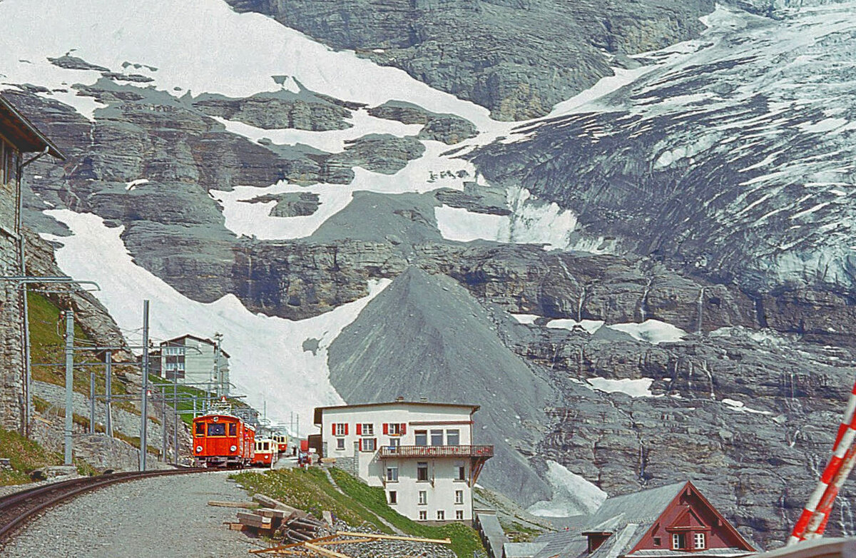 Station Eigergletscher am 5.August 1975, mit zwei Triebwagen und Lokomotive 11. Der Gletscher wirkt geradezu bedrohlich nah. 
