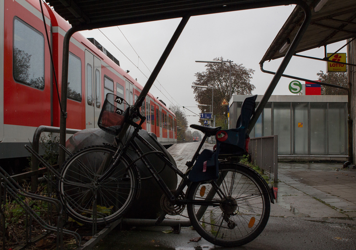 Sucht man unter dem Wellblechdach diverser Fahrradständer vor Regen und Schnee Schutz, um ein paar Züge zu fotografieren, so entstehen durchaus merkwürdige Ideen.

Auf einmal hat man ein Motiv, welches es wert war, daß es zur zufriedenstellenden Umsetzung mehrerer Versuche bedurfte.

So wurde eine Begegnung zweier S-Bahn-Züge in Poing am 06.11.16 im Bilde festgehalten.